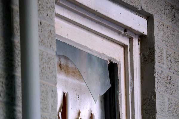 Broken glass window in fire damaged home